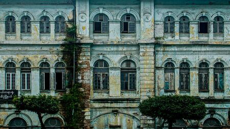 Decaying facade of an the old British colonial building, formerly the Accountant-Generals office, on the corner of Strand Rd and Pansdodan St in Yangon (formerly Rangoon), Myanmar (Burma)の写真素材