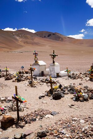 Graves in the desert cemetery outside the remote abandoned mining settlement ghost town of Mina La Casualidad, in the high altitude puna altiplano desert of Salta province in northern Argentinaの写真素材