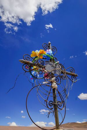Close-up of a cross marking a grave in the desert cemetery at the remote abandoned mining settlement of Mina La Casualidad, in the high altitude puna altiplano desert of Salta in northern Argentinaの写真素材