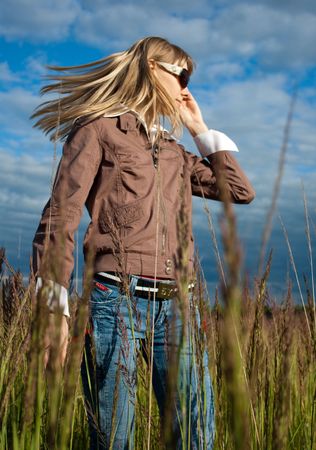 smiling beautiful girl standing in the green fieldの写真素材