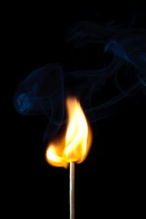 match burning with fire and smoke isolated on black backgroundの写真素材