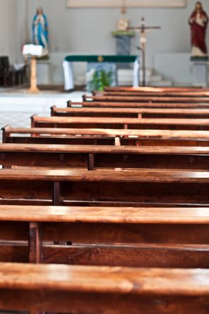 catholic church interior with front of seats in foreground with focus on itのeditorial素材