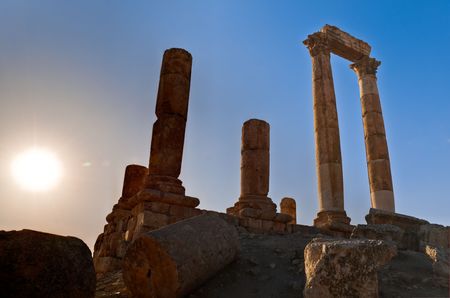 ancient ruins with sun and sunset sky in background (Temple of Hercules in Amman, Jordan)の写真素材