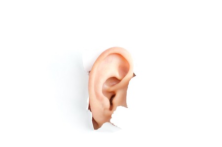 woman ear peeping out from white torn paper