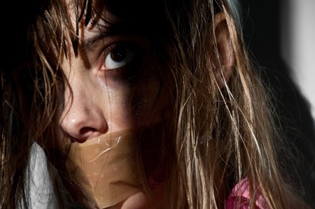 young woman taken hostage with her mouth gaggedの写真素材