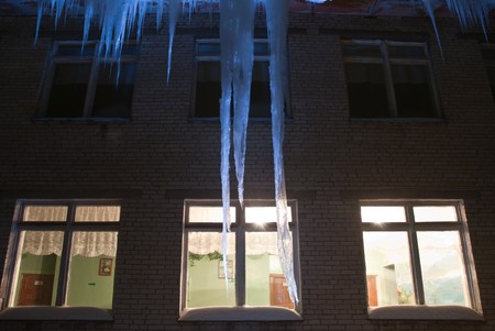 giant frosty icicles hanging down from the roofの写真素材