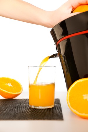 making orange juice from sliced oranges with help of juicerの写真素材