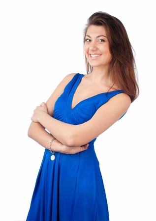 beautiful and sexy young woman with dark hair in blue dress. Looking into the camera and smiling her hands behind her. Isolated on white background.の写真素材