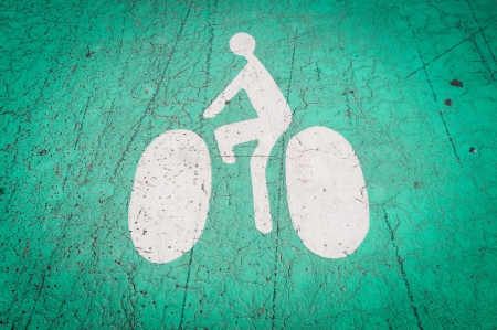 Icon of the bicycle with the cyclist on it on the ground. White symbol, green background. Nice, France, Europe.の写真素材