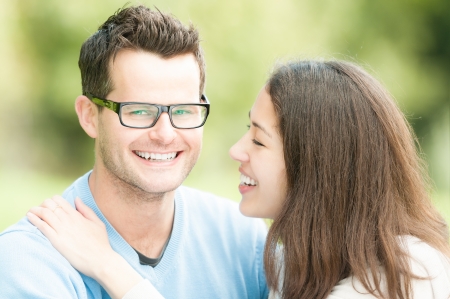 Portrait of beautiful romantic couple  People dating in park  Pretty woman with man in glasses and blue pullover  Green nature as background  Young positive family having leisure time outside の写真素材