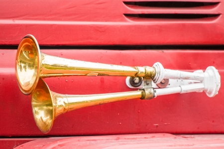 Close up view of two shiny metal horns on red firefighter car  Sound signal used to avoid traffic...