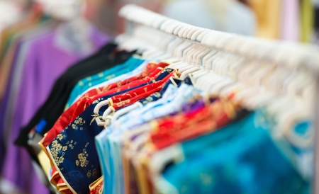 Rows of new colorful clothing on hangers at shop in foreground and background  の写真素材