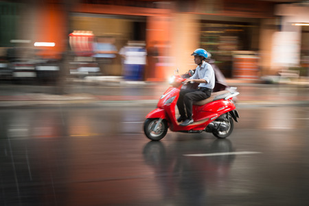 HANOI, VIETNAM - DECEMBER 7: Man in rain riding scooter. Most popular means of transport. Vietnam takes world 4th place in bike usage. December 7, 2012, Hanoi, Vietnam, Asia.のeditorial素材