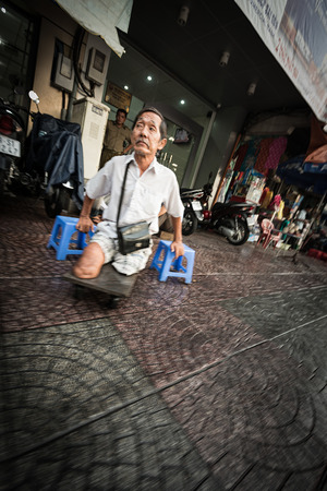 Ho Chi Minh, Vietnam - December 7, 2012. Disabled person on board using blue chairs for walking. 15% of the Vietnamese population lives with a disability still suffering from the after-effects of war.のeditorial素材