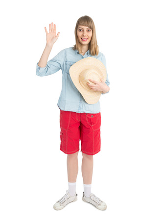 Happy lady tourist in blue shirt and red shorts with straw hat. Girl going to travel. Isolated on white background. Interesting trip on summer vacation.の写真素材