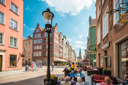 Gdansk, Poland - May 18, 2013. Street in Gdansk, Poland, Europe. Famous and interesting place for tourism. People walking and sitting in cafe. Beautiful sunny day with blue cloudy sky.のeditorial素材