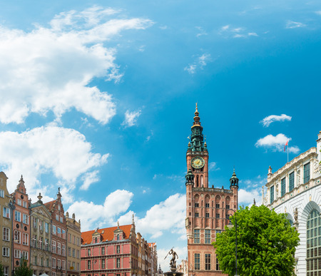 Old and colorful houses in street of Gdansk, Poland, Europe. Beautiful sunny day, blue cloudy sky. Gothic-Renaissance town hall tower.の写真素材