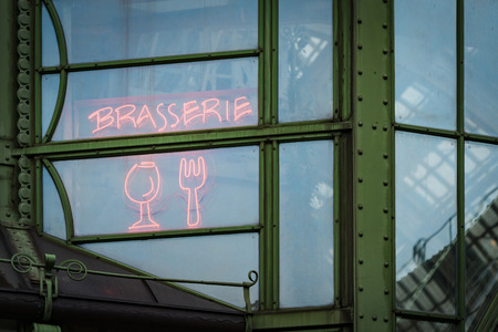 Details of street cafe in Vienna, Austria. Window with neon sign inscription brasserie, glass and fork. Europe travel.の写真素材