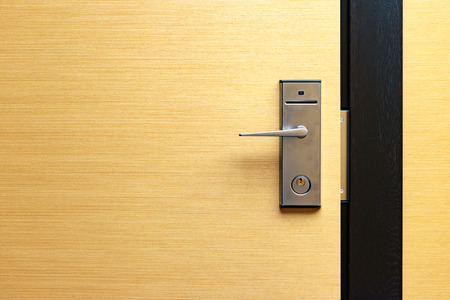 Contemporary lock with card access on wooden door in hotelの写真素材