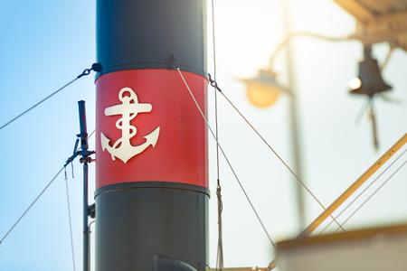 Old ship funnel with anchor sign in foreground and summer sky in background. Stockholm, Sweden, Scandinavia, Europe.の写真素材