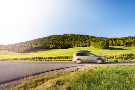 Car on country road in Norway, Europe, Scandinavia. Auto travel on sunny day. Blue sky with no clouds.の写真素材
