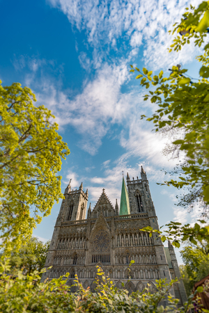View on facade of old Trondheim cathedral. Norway, Europe travel. Blue cloudy sky in backgroundの写真素材
