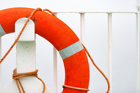 Orange lifebuoy on white wall in port. Norway, Scandinavia, Europe.の写真素材