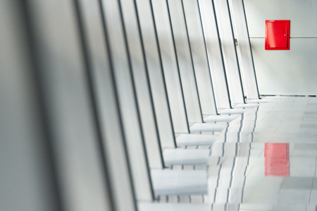 Architecture abstract, white columns at airport. Shining floor and red fire box. Modern design of public place.の写真素材