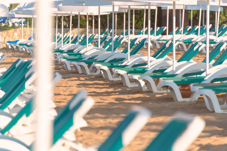 Beach in Turkey with sand in foreground, white sun shade umbrellas and chairs in backgroundのeditorial素材