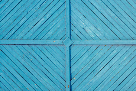Wooden fence with pattern painted white. Blue colored planksの写真素材