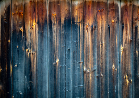Old wood plank background with cracks and lines. Light in the middle with space for copy, dark at the sides. Wall of house.の写真素材