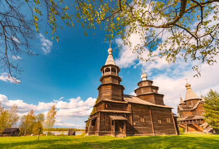 Church in Norway on sunny day with blue cloudy sky in background and green grass and cemetery in foregroundの写真素材