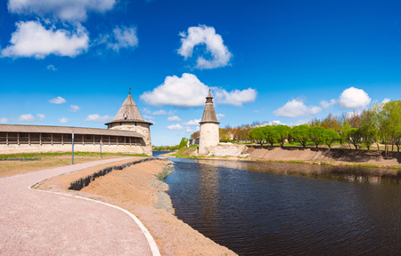 Pskov kremlin tower with blue cloudy sky in background. River in foreground.のeditorial素材