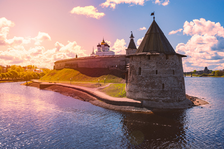 Pskov kremlin tower with blue cloudy sky in background. River in foreground.のeditorial素材