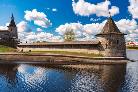 Pskov kremlin tower with blue cloudy sky in background. River in foreground.のeditorial素材