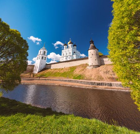 Pskov church and kremlin with blue cloudy sky in background. River in foreground.のeditorial素材