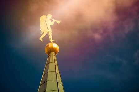 Golden angel windvane on top of church tower in Russia. Blue coudy sky in background.の写真素材