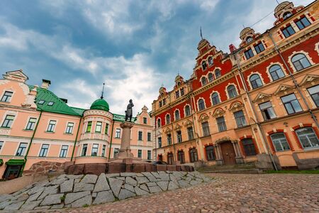 Old town hall of Vyborg city in Russia. Monument in foreground and blue cloudy sky in background.の写真素材