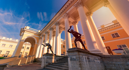 Two statues depicting ancient people. Old building with columns in background. Russia, Saint Petersburg, Europe travelのeditorial素材