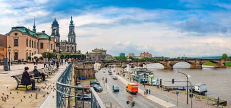 DRESDEN, GERMANY - SEPTEMBER 22, 2014: Katholische Hofkirche on the left and Semperoper on the right. People at river Elbe with bridge in background. Travel and architecture in Europeのeditorial素材