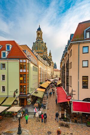 DRESDEN, GERMANY - SEPTEMBER 22, 2014: Old street with Frauenkirche cathedral in Dresden, Germany. Church of Our Lady is a Lutheran church in state of Saxony. View from square with people walking aroundのeditorial素材