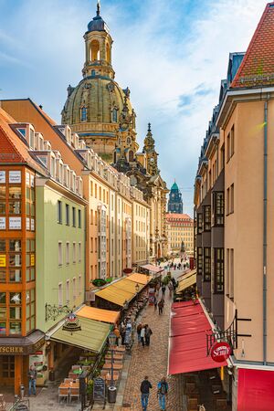 DRESDEN, GERMANY - SEPTEMBER 22, 2014: Old street with Frauenkirche cathedral in Dresden, Germany. Church of Our Lady is a Lutheran church in state of Saxony. View from square with people walking aroundのeditorial素材