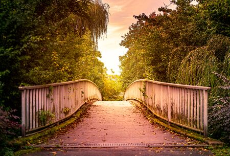 Old bridge in park of in town of Bad Mergentheim, Bavaria, Germany, Europe. Sunset cloudy sky in backgroundの写真素材