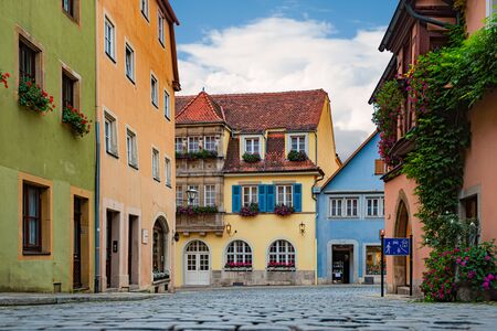 Empty old street in Rothenburg Ob Der Tauber, Bavaria, Germany, Europe. Old german architecture. Blue cloudy sky in backgroundの写真素材