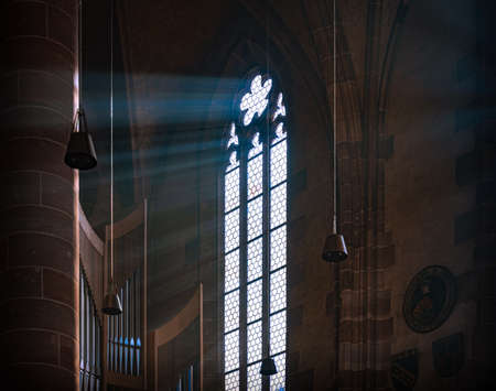 Sun rays beaming through the old stained glass window of Nurnberg cathedral in Bavaria, Germany, Europe.の写真素材