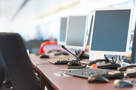 Computers at airport boarding gate. No people in image. Focus on nearest display with soft backgroundのeditorial素材