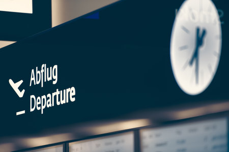 Close up view of black sign with big white inscription Departure and clock. Arit trips and travelling.のeditorial素材