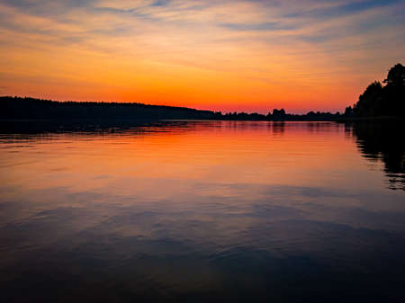 Sunset at lake, sky with clouds in background and pier in foregroundの写真素材
