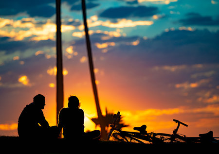 Couple at sunset beach in Santa Monica, California, United States of America. Sun and clouds in background.の写真素材