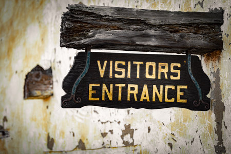 Old visitors entrance sign on wall, California, USAの写真素材